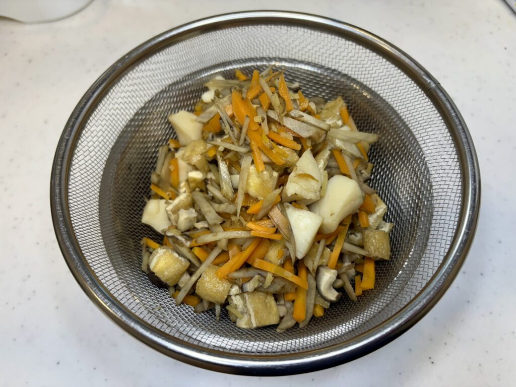 ホタテの炊き込みご飯の具材を出汁と分ける画像